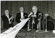 Fotografia de Américo Tomás condecorando a bandeira durante a sessão solene do 1.º centenário da fundação do Banco Nacional Ultramarino, na Sociedade de Geografia de Lisboa