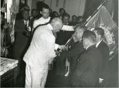 Fotografia de Américo Tomás acompanhado por António Augusto Peixoto Correia assistindo a sessão solene na Câmara Municipal de Maputo, por ocasião da visita de estado efetuada a Moçambique