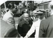 Fotografia de Américo Tomás, acompanhado por Alfredo Rodrigues dos Santos Júnior, saudando a população em Alijó por ocasião da visita efetuada por ocasião da visita efetuada ao distrito de Bragança, de 29 a 31 de agosto de 1964