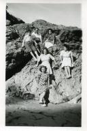 Fotografia de Maria Natália e Maria Madalena, filhas de Américo Tomás, com familiares e amigos sentados nas rochas junto à Praia de Alpertuche na Arrábida, em Setúbal