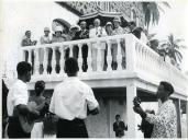 Fotografia de Américo Tomás, acompanhado por Gertrudes Rodrigues Tomás e por António Augusto Peixoto Correia, assistindo a uma atuação de músicos na varanda de uma residência na Ilha do Príncipe, por ocasião da visita oficial efetuada a São Tomé e Príncipe