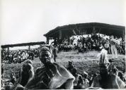 Fotografia de Américo Tomás, acompanhado por António Augusto Peixoto, em Quissico, assistindo a um evento, por ocasião da visita de estado efetuada a Moçambique