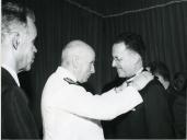 Fotografia de Américo Tomás, acompanhado por Eduardo de Arantes e Oliveira e, atribuindo condecorações, por ocasião da cerimónia oficial de inauguração da Doca de Pescas de Pedrouços
