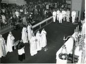 Fotografia de Américo Tomás acompanhado por Gertrudes Rodrigues Tomás assistindo a missa Te-Deum na catedral na cidade de Maputo, por ocasião da visita de estado efetuada a Moçambique