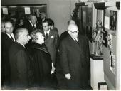 Fotografia de Américo Tomás acompanhado de Gertrudes Rodrigues Tomás assistindo à inauguração de uma exposição na Junta de Turismo da Costa do Sol, no Estoril