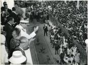 Fotografia de Américo Tomás, acompanhado por Gertrudes Rodrigues Tomás e por António Augusto Peixoto Correia, saudando a população da Ilha de Moçambique por ocasião da visita de estado efetuada a Moçambique