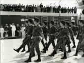 Fotografia de Américo Tomás, acompanhado por José Augusto da Costa Almeida e por António Augusto Peixoto Correia, em Vila Cabral, atualmente designada Lichinga, assistindo a um desfile militar por ocasião da visita de estado efetuada a Moçambique