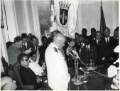 Fotografia de Américo Tomás, acompanhado por António Augusto Peixoto Correia, discursando na câmara municipal da Ilha do Príncipe, por ocasião da visita oficial efetuada a São Tomé e Príncipe