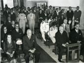 Fotografia de Américo Tomás, acompanhado por Eduardo de Arantes e Oliveira, na Ermida de Santo Amaro, assistindo a uma missa de homenagem aos operários mortos durante a construção da Ponte Salazar, atualmente denominada Ponte 25 de Abril