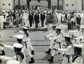 Fotografia de Américo Tomás, acompanhado por António Augusto Peixoto Correia e por Silvino Silvério Marques, assistindo a um desfile militar em Luanda, por ocasião de uma visita de estado efetuada a Angola