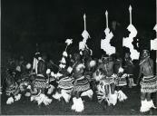 Fotografia de um grupo de homens efetuando danças tribais na cidade de Maputo, por ocasião da visita de estado de Américo Tomás efetuada a Moçambique