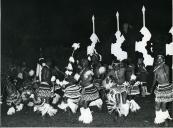 Fotografia de um grupo de homens efetuando danças tribais na cidade de Maputo, por ocasião da visita de estado de Américo Tomás efetuada a Moçambique