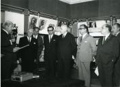 Fotografia de Américo Tomás, acompanhado por César Moreira Batista, nas instalações do SNI, presidindo à inauguração de uma exposição retrospetiva dos Prémios Literários e Artísticos do SNI