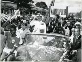 Fotografia de Américo Tomás, acompanhado por António Augusto Peixoto Correia, seguindo em cortejo automóvel na cidade da Beira, por ocasião da visita de estado efetuada a Moçambique