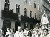 Fotografia de Américo Tomás, acompanhado por Gertrudes Rodrigues Tomás, na varanda do Banco Nacional Ultramarino, assistindo à passagem da procissão em honra de Nossa Senhora da Saúde