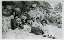 Fotografia de Maria Natália e Maria Madalena, filhas de Américo Tomás, com familiares e amigos deitados na areia da Praia de Alpertuche na Arrábida, em Setúbal