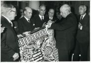 Fotografia de Américo Tomás, acompanhado por António Augusto Peixoto Correia e por Eduardo de Arantes e Oliveira, condecorando a bandeira do Diário de Notícias