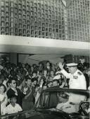 Fotografia de Américo Tomás em cortejo automóvel saudando a população, por ocasião da visita de estado efetuada a Moçambique