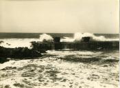 Fotografia dum porto na costa portuguesa durante condições marítimas adversas