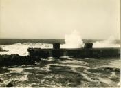 Fotografia dum porto na costa portuguesa durante condições marítimas adversas