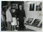 Fotografia de Américo Tomás na Junta de Turismo da Costa do Sol, visitando uma exposição de fotografias a cores sobre Angola.