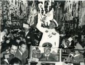 Fotografia de Américo Tomás no interior de um automóvel descapotável sendo saudado pela população no regresso da visita de estado a Moçambique, São Tomé e Príncipe e com passagem em Angola, nas ruas de Lisboa