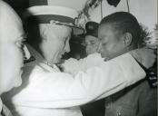 Fotografia de Américo Tomás, acompanhado por António Augusto Peixoto Correia, condecorando um soldado por ocasião da visita de estado efetuada a Moçambique