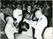 Fotografia de Américo Tomás, acompanhado por César Moreira Batista, em Xai-Xai, condecorando um militar por ocasião da visita de estado efetuada a Moçambique