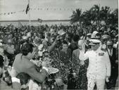 Fotografia de Américo Tomás, acompanhado por José Augusto da Costa Almeida e por António Augusto Peixoto Correia, saudando a população por ocasião da visita de estado efetuada a Moçambique