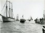 Fotografia de uma frota de embarcações de pesca do bacalhau, no rio Tejo, por ocasião da cerimónia da bênção dos bacalhoeiros