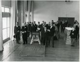 Fotografia de Américo Tomás acompanhado por Eduardo de Arantes e Oliveira e por outras individualidades no interior de um ginásio durante a visita efetuada ao Alentejo de 12 a 14 de abril