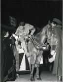 Fotografia de vários atores participando na encenação de um duelo medieval a cavalo. 