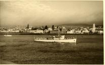 Fotografia dum navio de guerra passando em frente às Portas da Cidade de Ponta Delgada, nos Açores