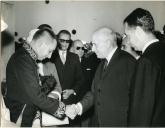 Fotografia de Américo Tomás, acompanhado por António Augusto Peixoto Correia e por Silvino Silvério Marques, cumprimentando um militar em Luanda, por ocasião de uma visita de estado efetuada a Angola