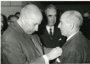 Fotografia de Américo Tomás, acompanhado por Eduardo de Arantes e Oliveira, condecorando um operário em Miranda do Douro, por ocasião da inauguração da barragem da Bemposta