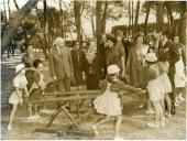 Fotografia de Américo Tomás, acompanhado por Gertrudes Rodrigues Tomás e rodeados por crianças, por ocasião da visita efetuada à Colónia Balnear infantil da C.U.F. no sítio do Pego Longo, freguesia de Colares 