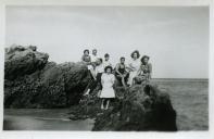 Fotografia de Maria Natália e Maria Madalena, filhas de Américo Tomás, com familiares e amigos sentados nas rochas junto à Praia de Alpertuche na Arrábida, em Setúbal
