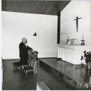 Fotografia de Américo Tomás rezando na igreja, por ocasião da inauguração do Bairro da SACOR, em Sacavém