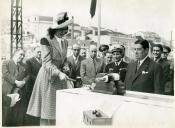 Fotografia da madrinha de um dos navios arrastões destinados à pesca do bacalhau preparando-se para lançar a garrafa de champanhe inaugural por ocasião da cerimónia da flutuação dos navios “Pedro de Barcelos” e “João Álvaro Fagundes”