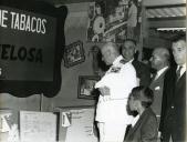 Fotografia de Américo Tomás, acompanhado por António Augusto Peixoto Correia, em Vila Pery, atualmente designada Chiomio, percorrendo a Feira Industrial, por ocasião da visita de estado efetuada a Moçambique