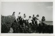 Fotografia de Maria Natália e Maria Madalena, filhas de Américo Tomás, com familiares e amigos sentados nas rochas junto à Praia de Alpertuche na Arrábida, em Setúbal