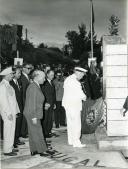 Fotografia de Américo Tomás, acompanhado por José Augusto da Costa Almeida e por António Augusto Peixoto Correia, descerrando uma lápide durante uma cerimónia de inauguração, por ocasião da visita de estado efetuada a Moçambique