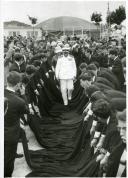 Fotografia de Américo Tomás acompanhado por Gertrudes Rodrigues Tomás na cidade da Guarda, caminhando sobre as capas de estudantes universitários