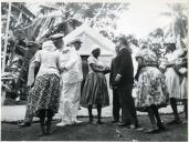 Fotografia de Américo Tomás, acompanhado por António Augusto Peixoto Correia, cumprimentando um conjunto de senhoras na Ilha do Príncipe, por ocasião da visita oficial efetuada a São Tomé e Príncipe