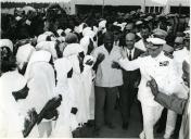 Fotografia de Américo Tomás acompanhado por António Augusto Peixoto Correia saudando a população de Quelimane durante a visita de estado efetuada a Moçambique