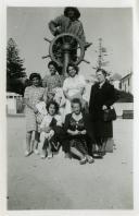 Fotografia de Gertrudes Tomás, mulher de Américo Tomás, com as filhas Maria Natália e Maria Madalena, com familiares e amigos junto à escultura “O Homem do Leme”, a autoria do escultor Américo Gomes em homenagem aos pescadores, por ocasião da sua visita ao norte de Portugal