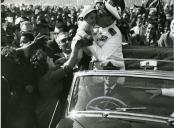 Fotografia de Américo Tomás beijando uma criança durante o cortejo automóvel na cidade de Maputo, por ocasião da visita de estado efetuada a Moçambique