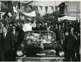 Fotografia de Américo Tomás saudando a população no interior da viatura oficial na cidade de Chimoio, durante a visita de estado efetuada a Moçambique