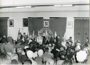 Fotografia de Américo Tomás, acompanhado por José Augusto da Costa Almeida e por António Augusto Peixoto Correia, discursando durante uma cerimónia oficial, por ocasião da visita de estado efetuada a Moçambique
