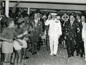 Fotografia de Américo Tomás, acompanhado por José Augusto da Costa Almeida e por António Augusto Peixoto Correia, saudando a população por ocasião da visita de estado efetuada a Moçambique